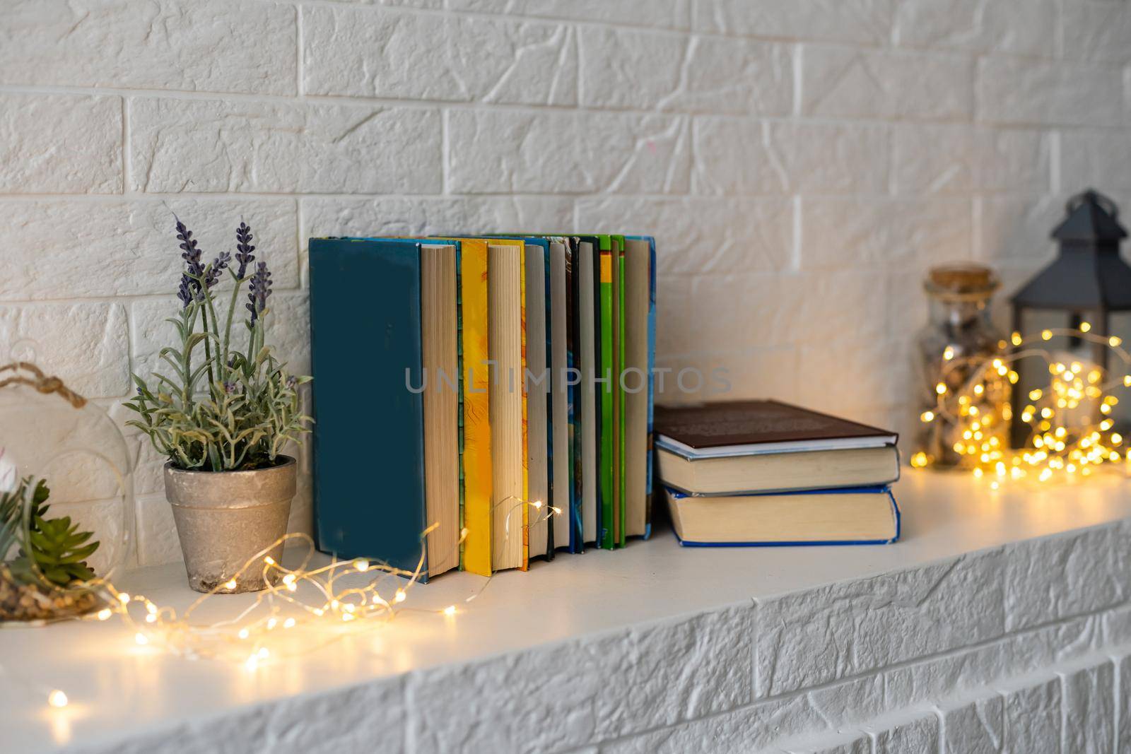 shelf with a book by the fireplace with a gerland.