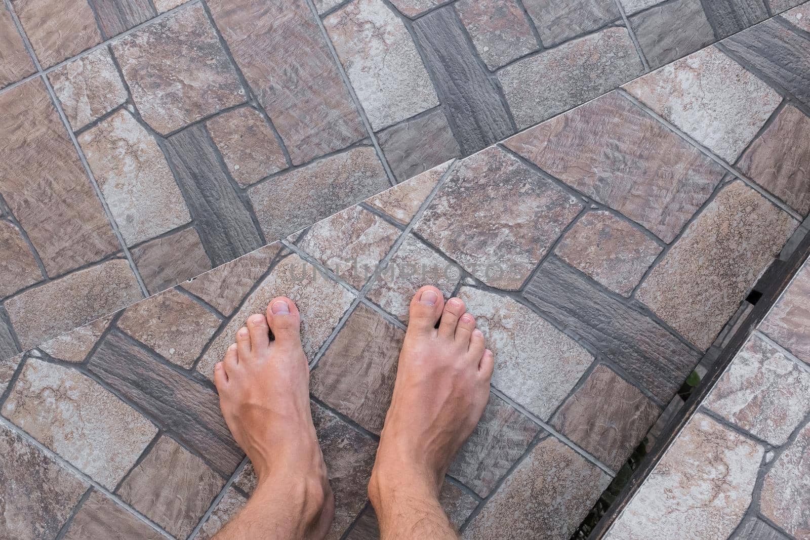 The guy's bare feet go down the stairs. Legs step down, the concept of walking.