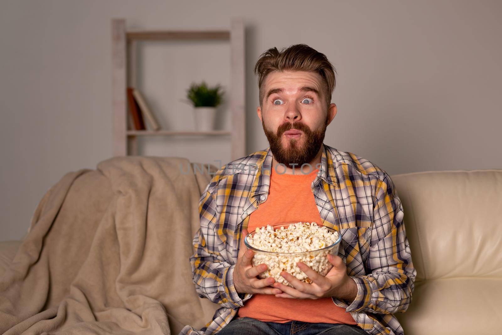single man on the couch watching TV in a room