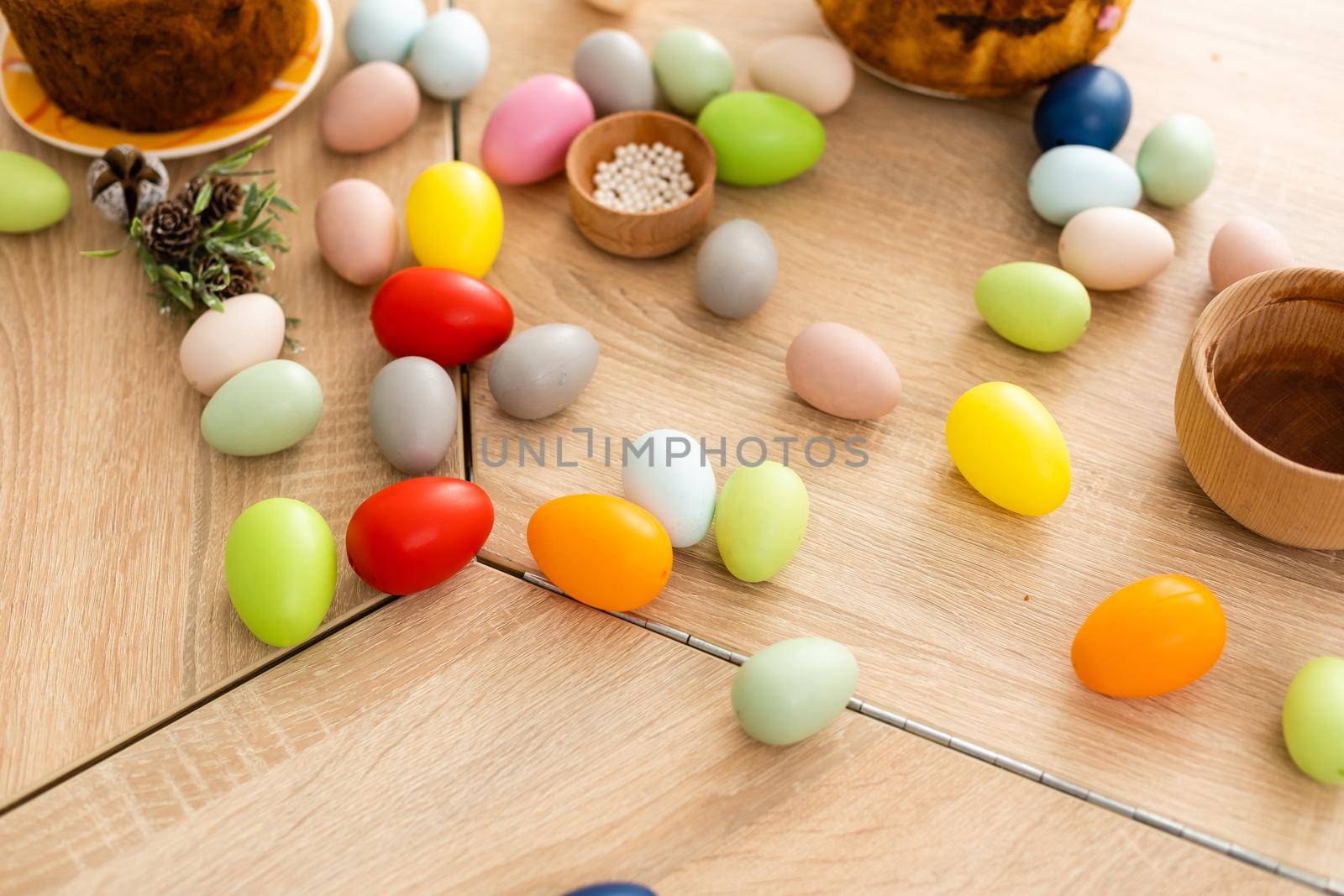 Easter cake and colorful eggs and flowers on the foreground.