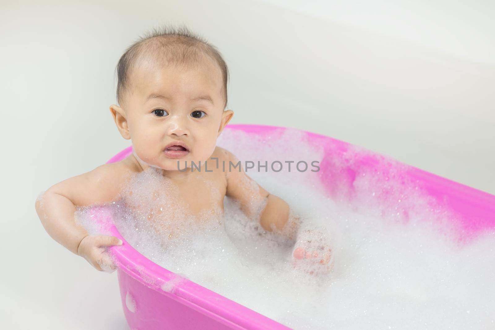 baby taking a bath in bathtub and playing with foam bubbles by geargodz