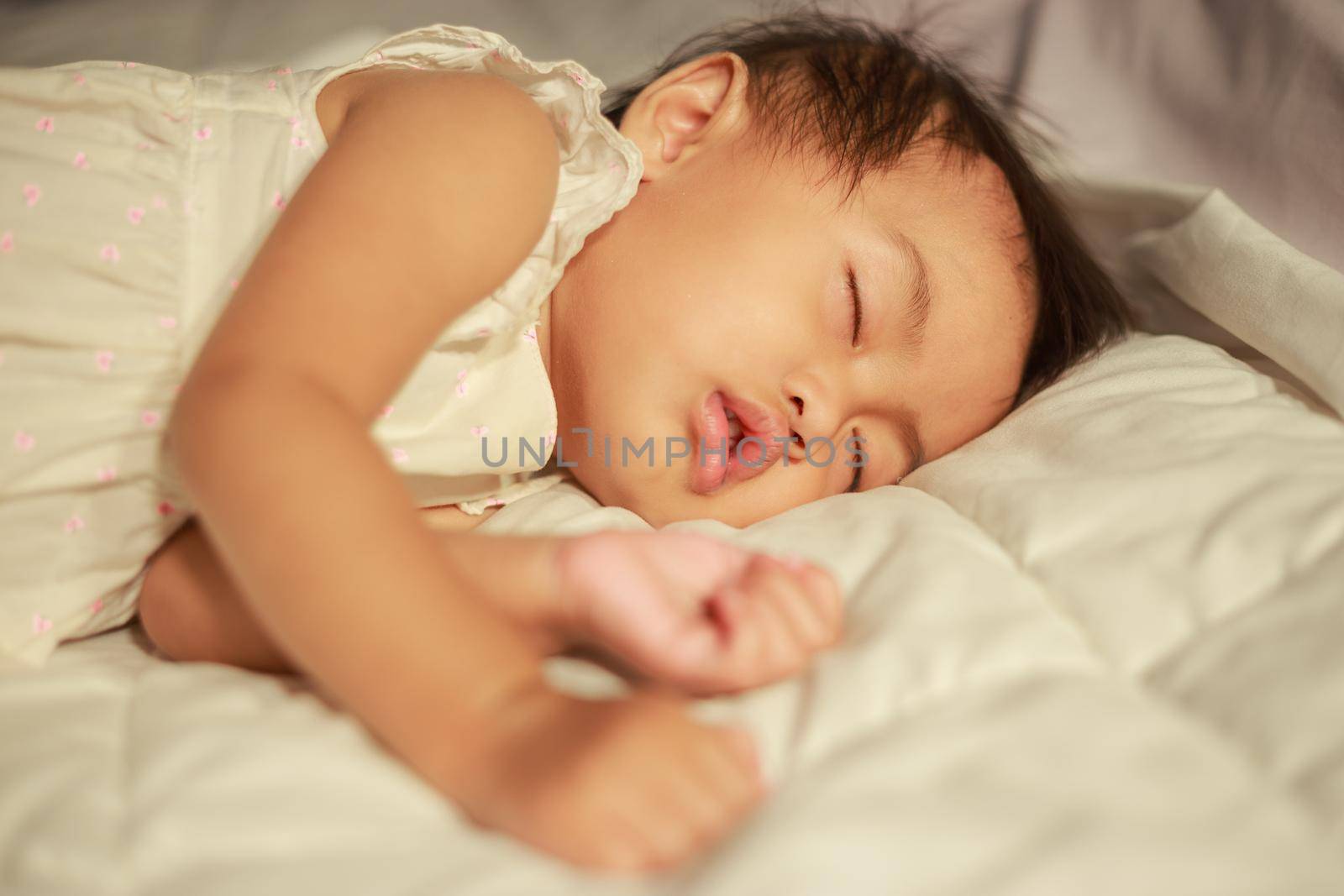 baby sleeping on bed in bedroom at home