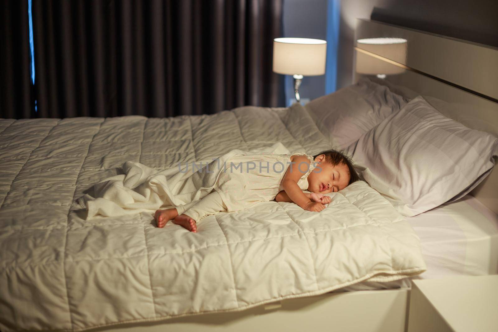 baby sleeping on bed in bedroom at home