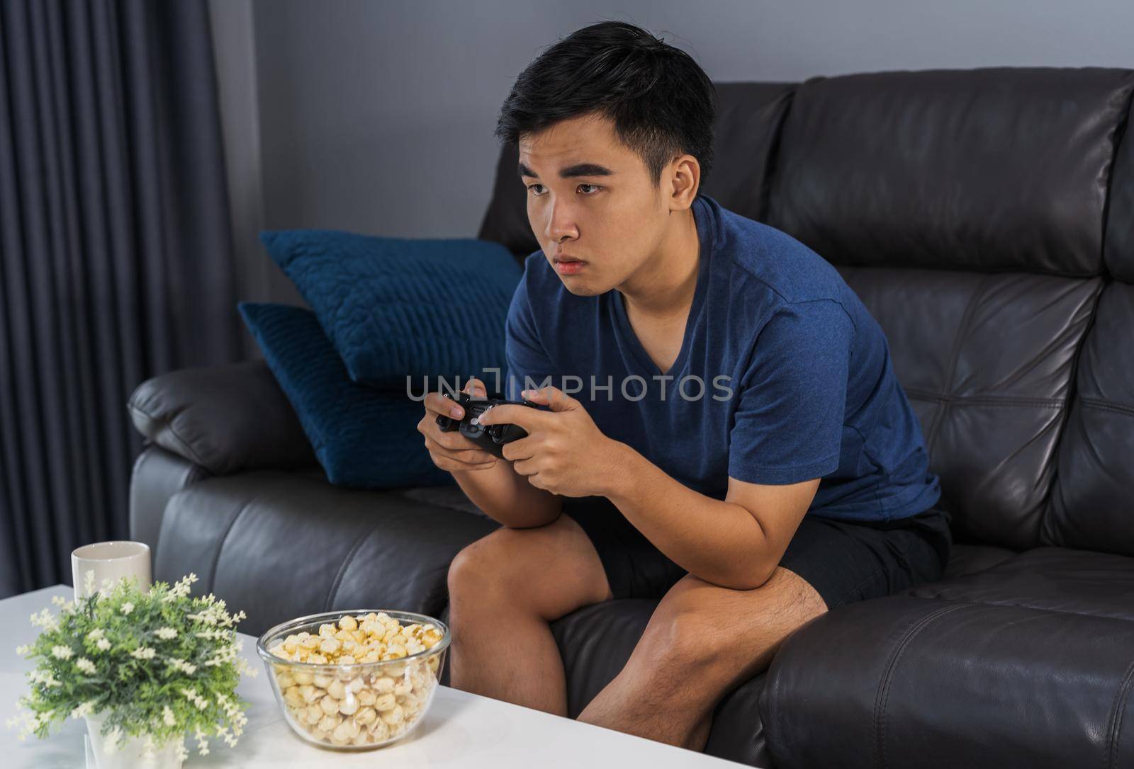 young man playing video game with joystick in the living room