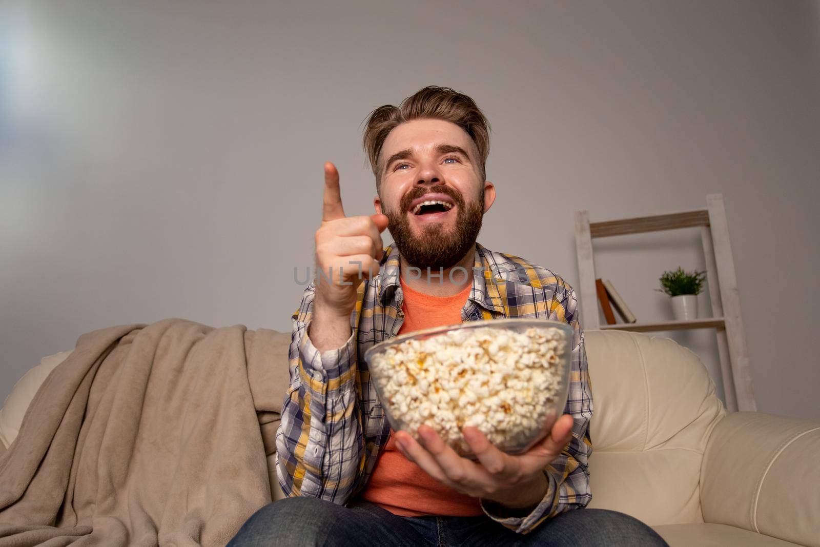 single man on the couch watching TV in a room
