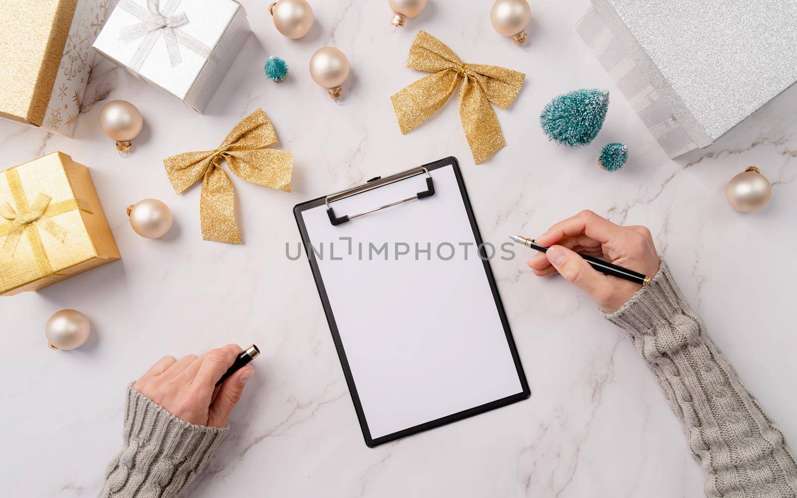 New Year Resolution and Motivation Concept. top view hands writing new year goals, resolution or shopping list on a blank paper. Mock up design