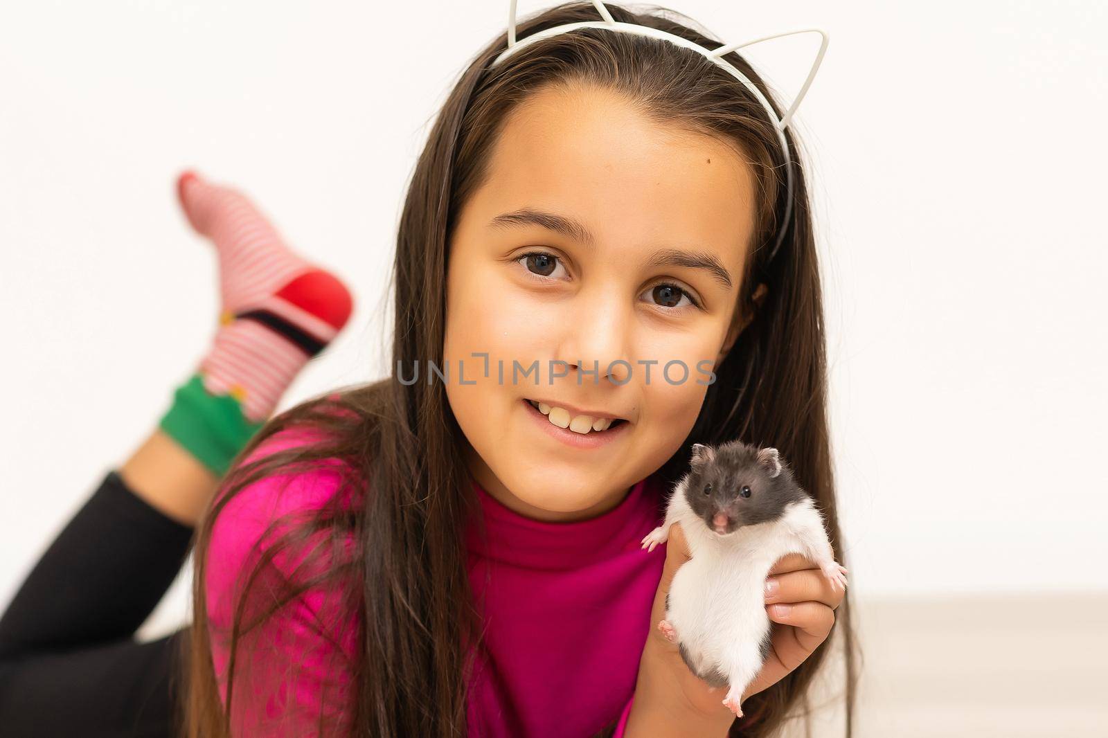 Little girl playing with cute hamster at home,