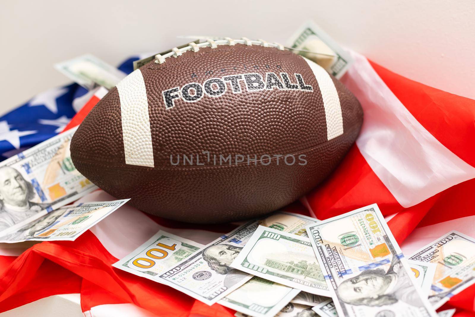 Money and rugby ball on american flag background, closeup. Concept of sports bet.