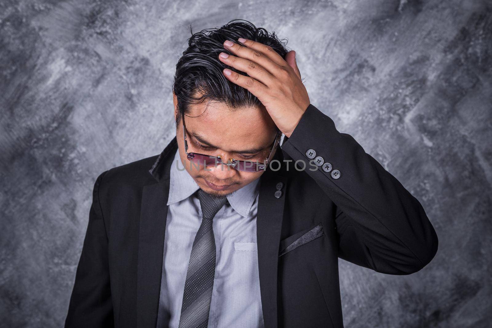 young business man in suit with headache and problems