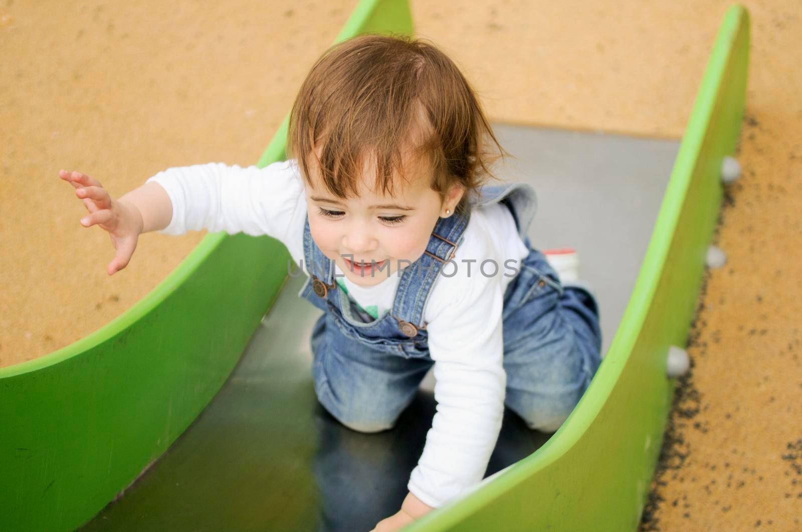 Little girl playing in a urban playground. by javiindy