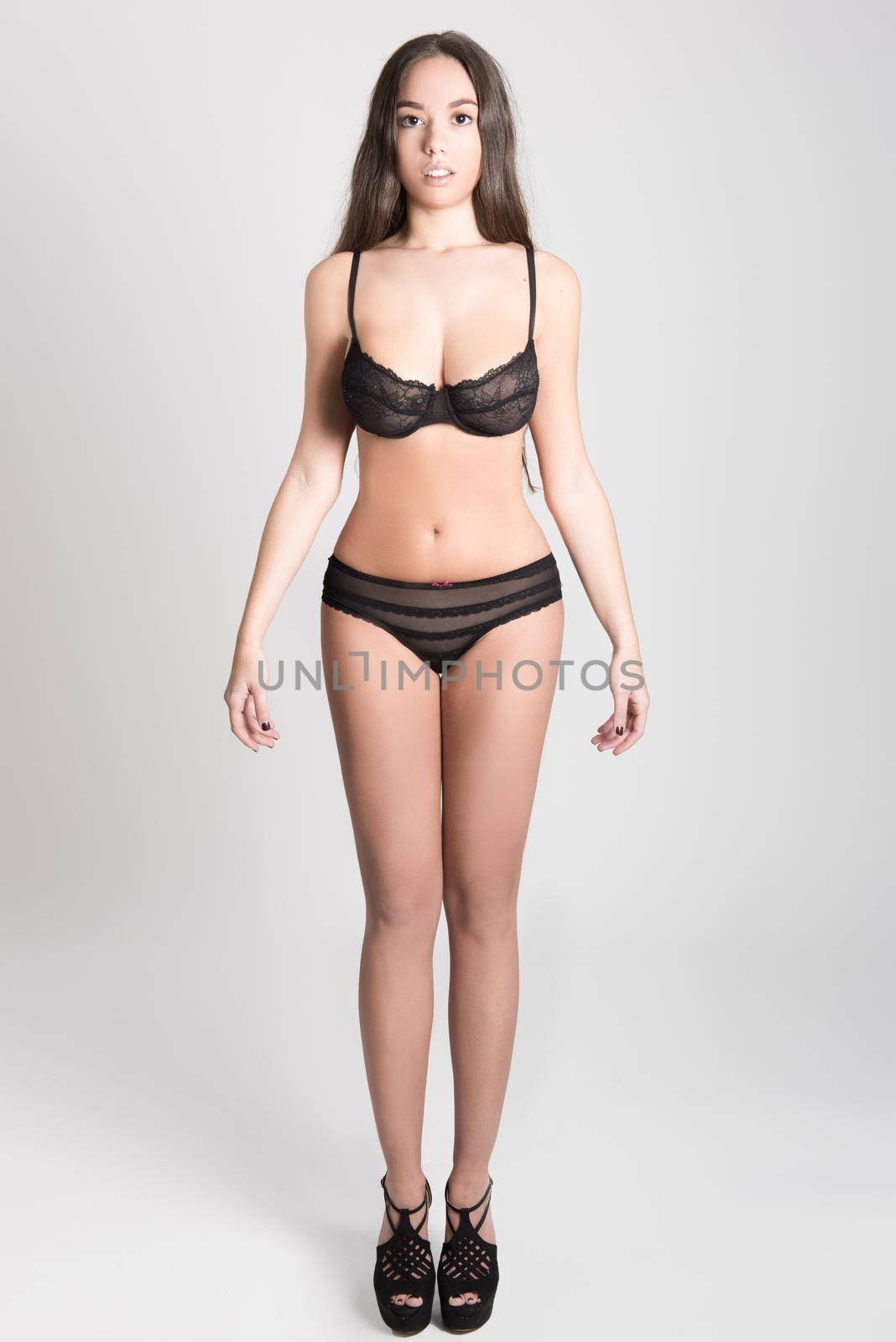 Portrait of young woman with long hair in lingerie on white background