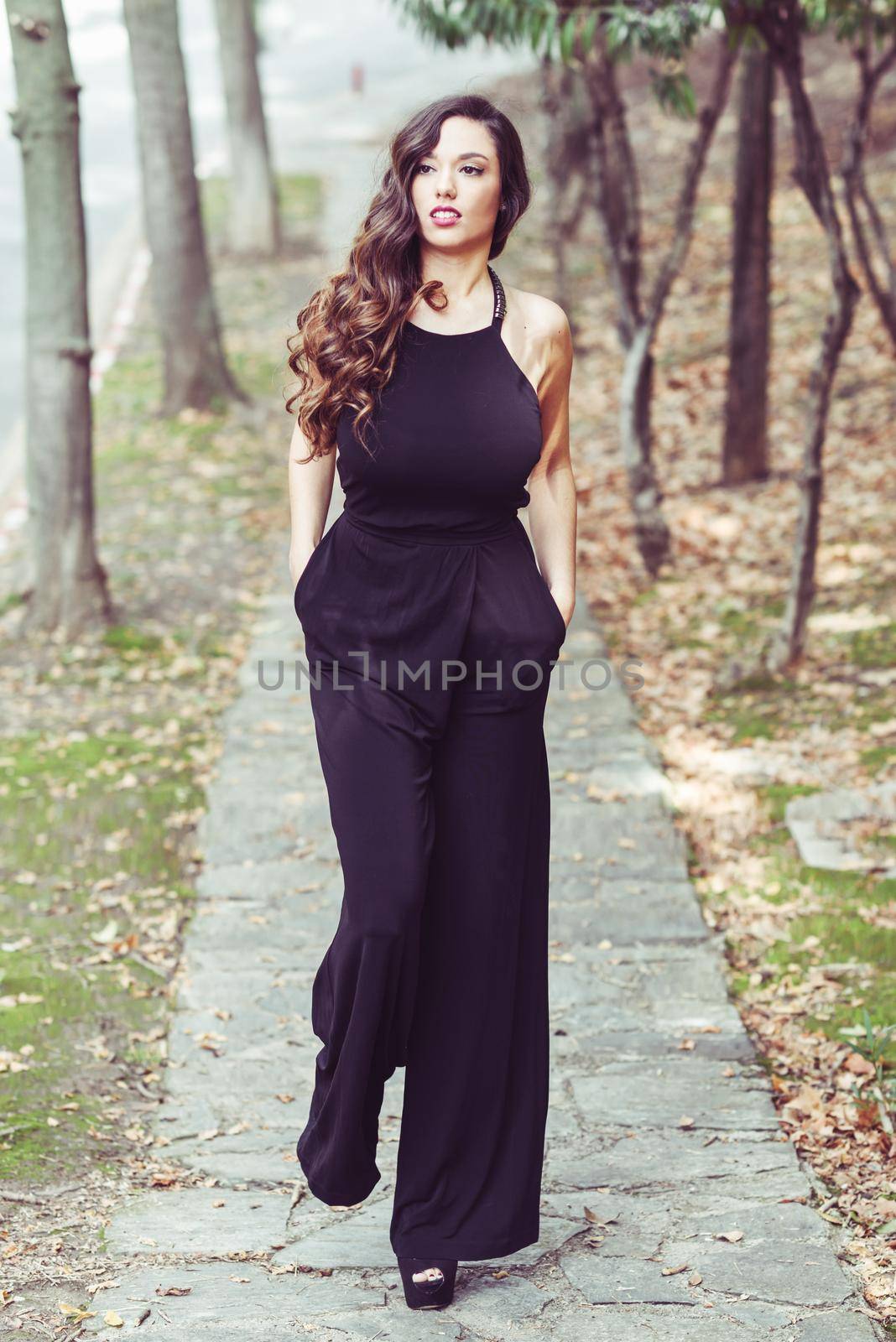 Portrait of pretty girl with long hair wearing black clothes in a park