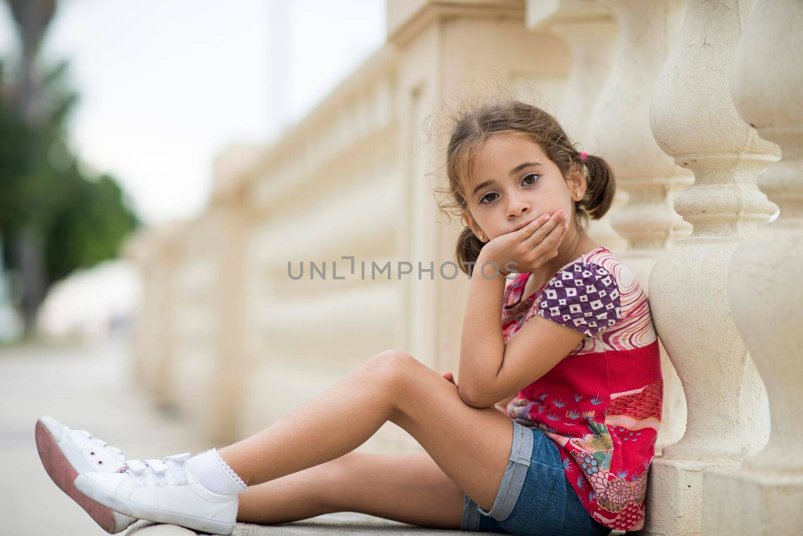 Adorable little girl combed with pigtails sitting on floor by javiindy