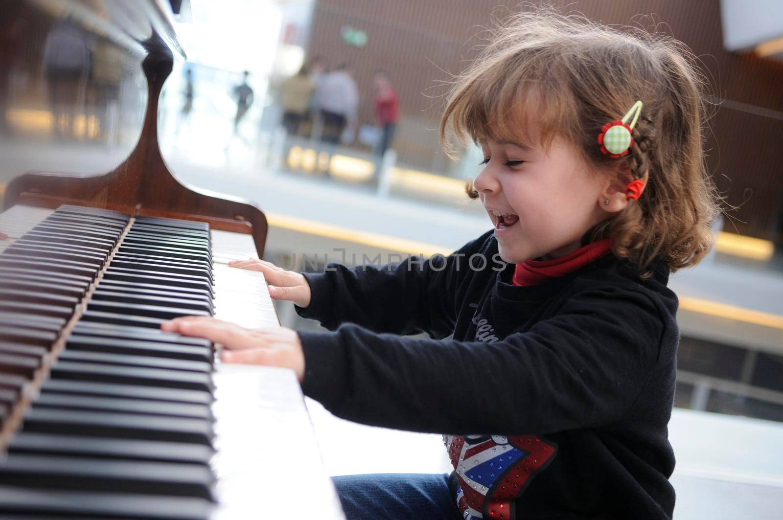 Adorable little girl having fun playing the piano