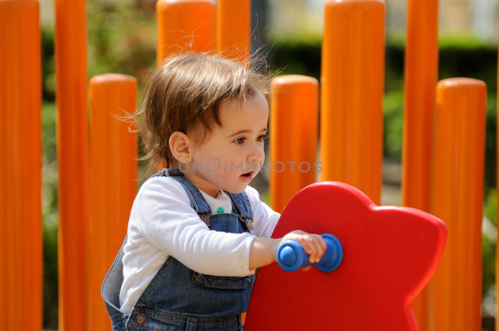 Little girl playing in a urban playground. by javiindy