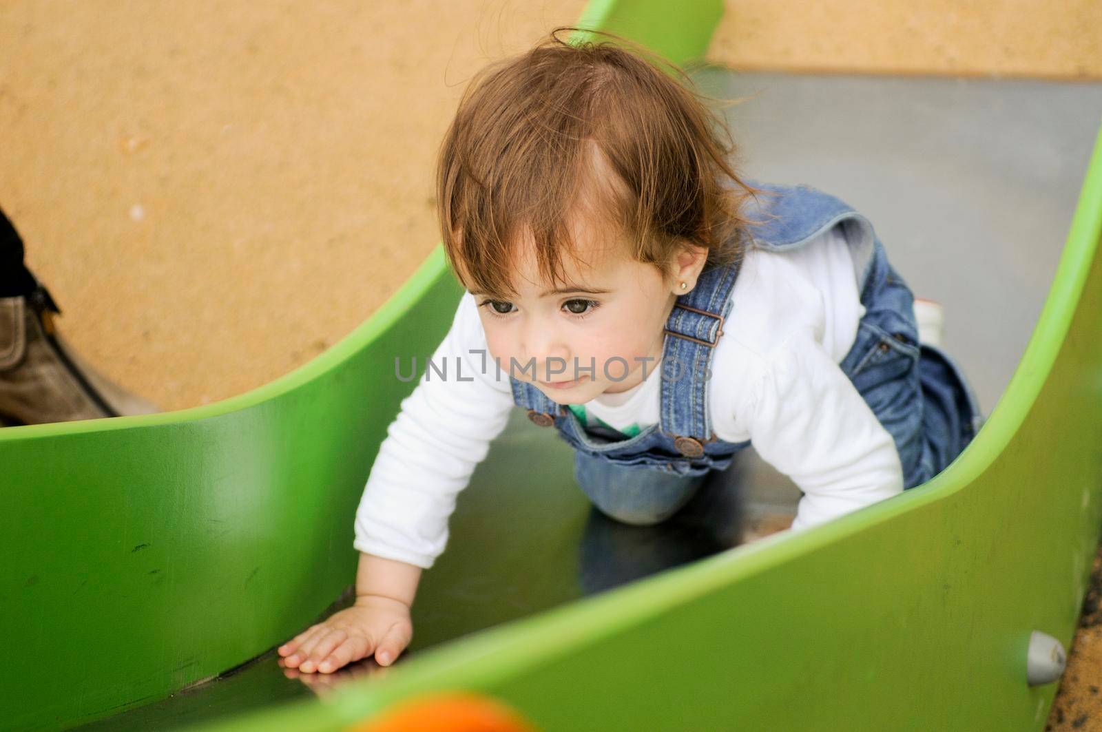 Happy little girl playing in a urban playground.