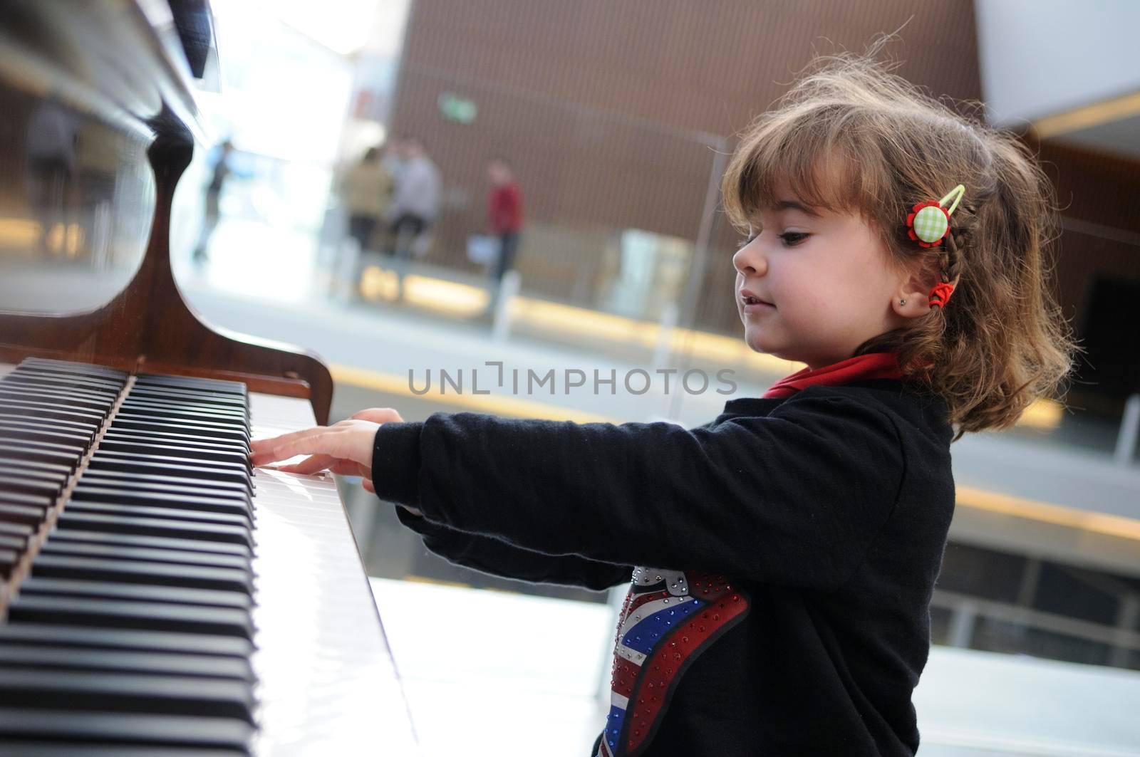 Adorable little girl having fun playing the piano