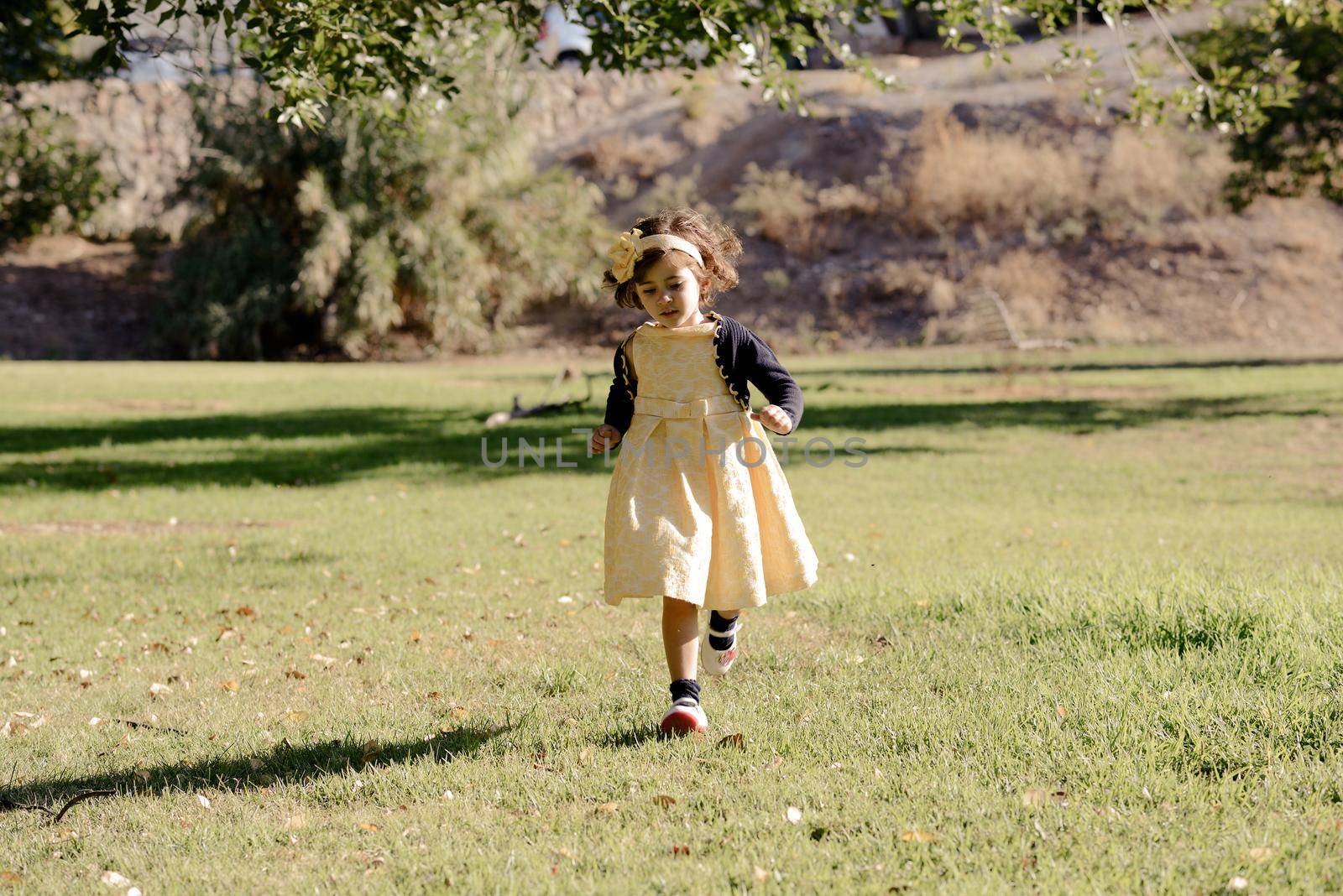 Little girl running and playing in the park by javiindy