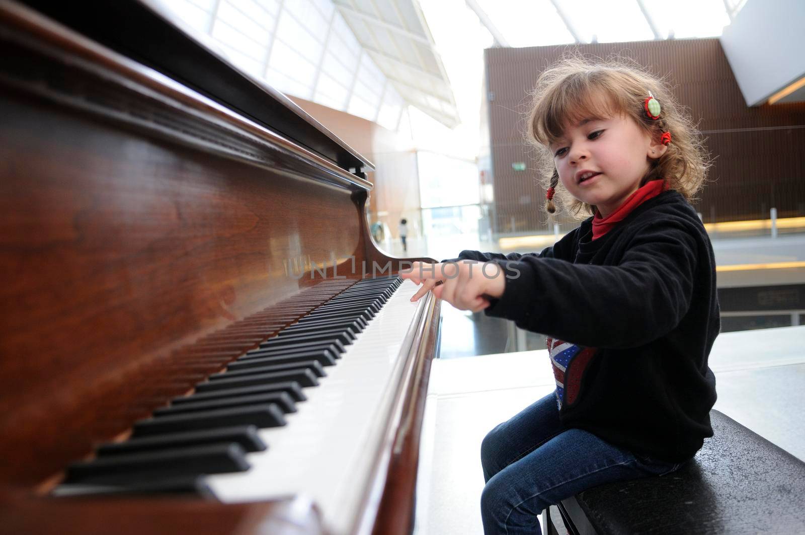 little girl having fun playing the piano by javiindy