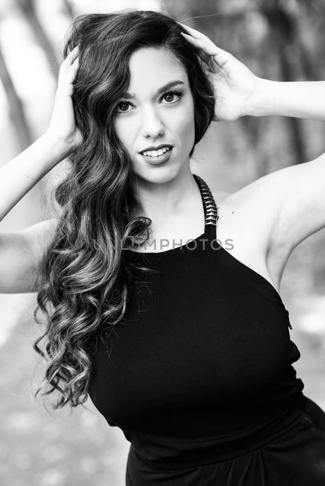 Portrait of pretty girl with long hair wearing black clothes in a park