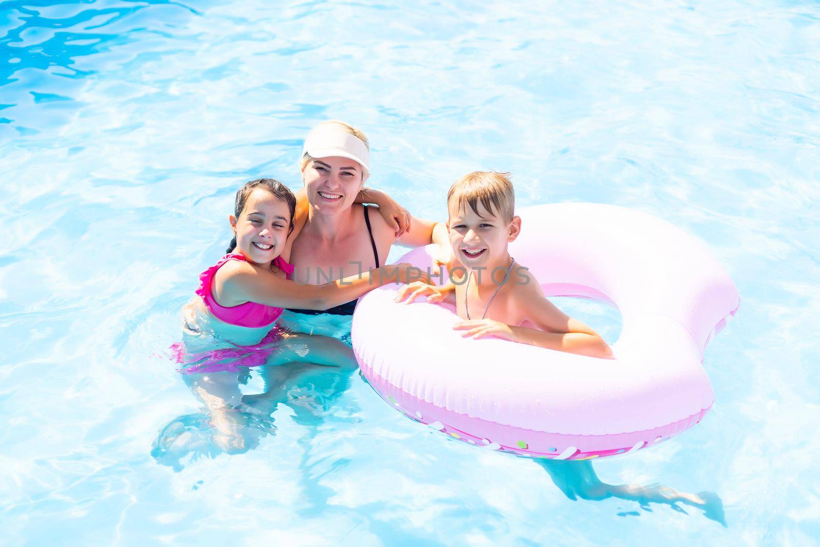 Young family, parents with children, in pool.