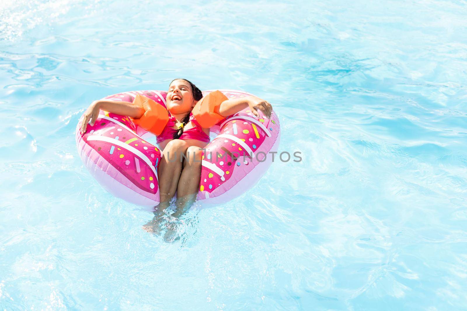 Little girl in swimming pool. Summer outdoor