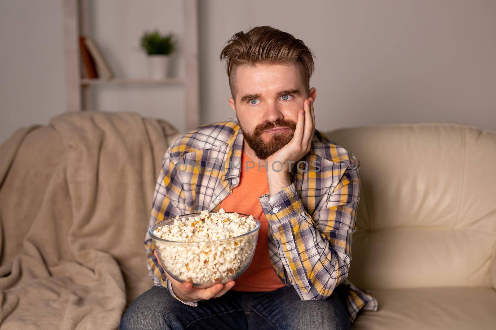 single man on the couch watching TV in a room