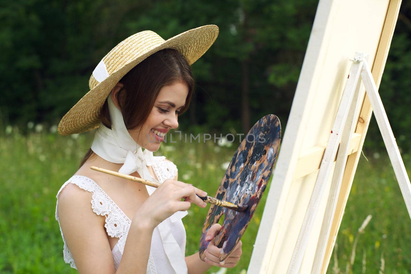 Woman in white dress outdoors artist drawing easel. High quality photo