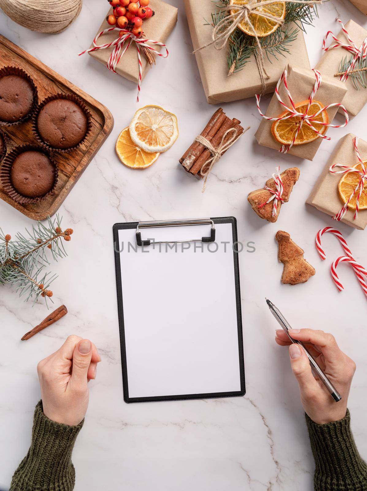 New Year Resolution and Motivation Concept. top view hands writing new year goals, resolution or shopping list on a blank paper. Mock up design