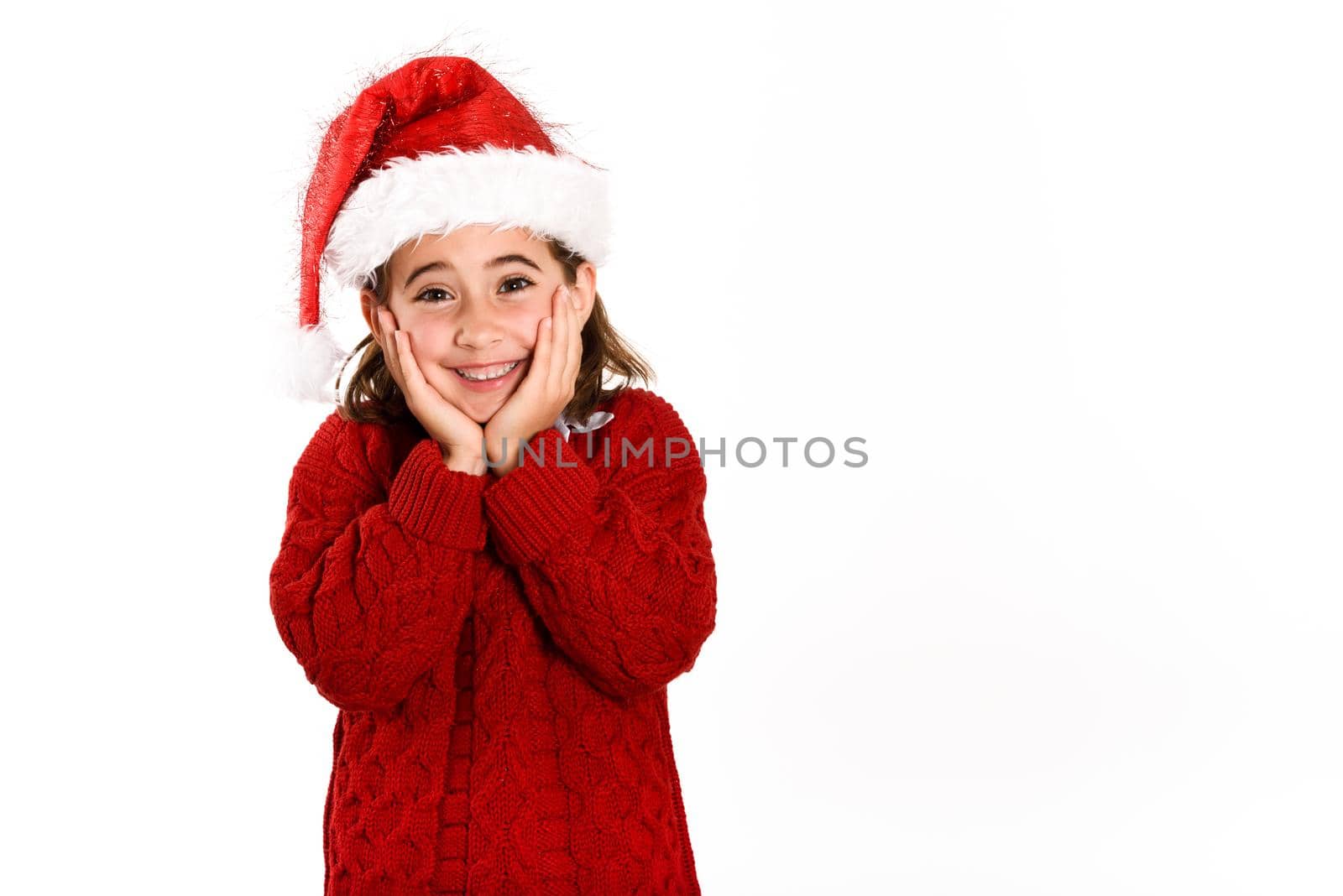 Adorable little girl wearing santa hat isolated on white background. Winter clothes for Christmas