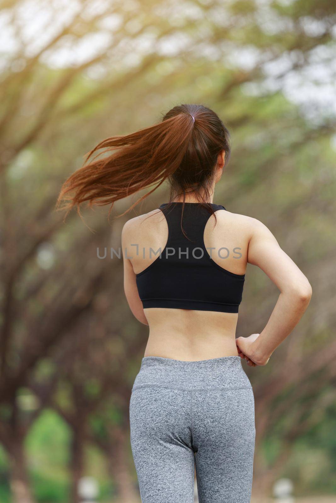 young fitness woman running in park by geargodz