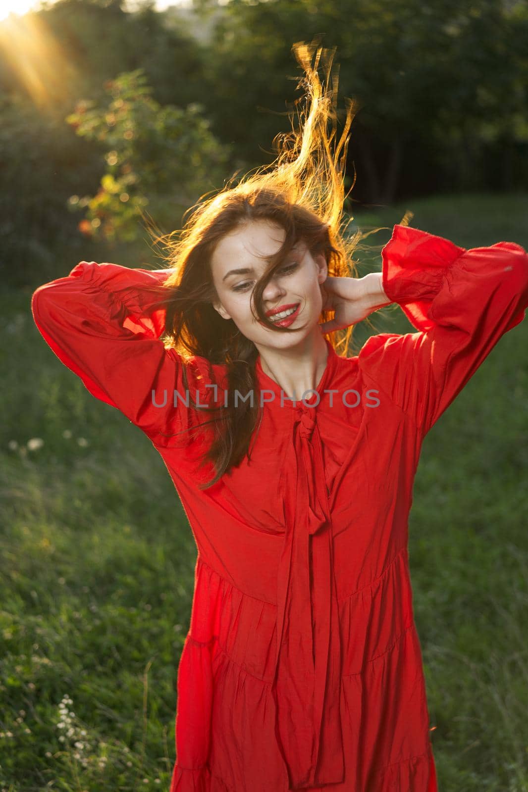 woman in red dress posing nature sun fun. High quality photo