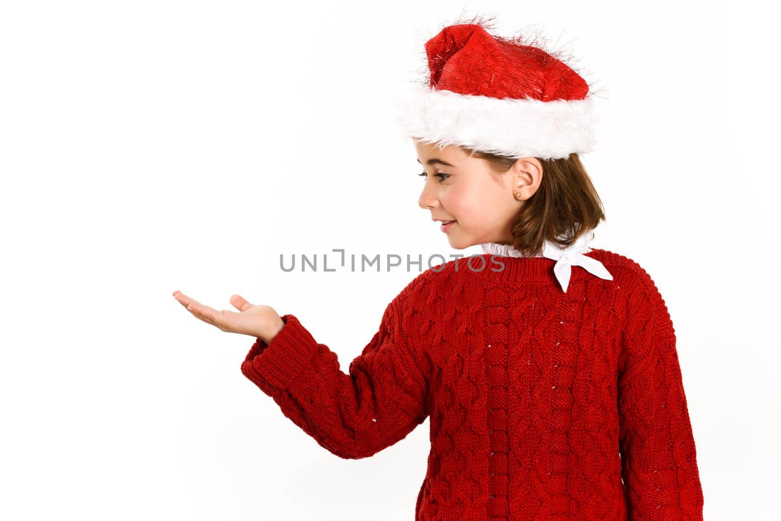 Adorable little girl wearing santa hat isolated on white background by javiindy