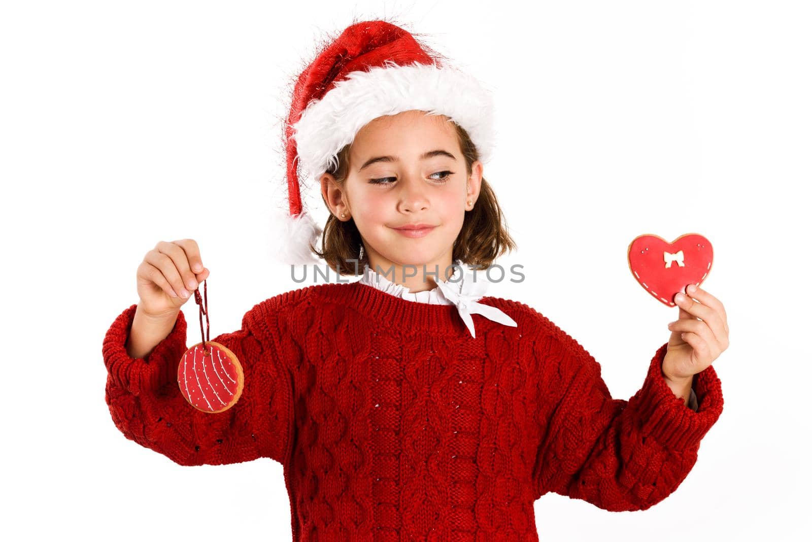 Adorable little girl wearing santa hat with Christmas cookies by javiindy