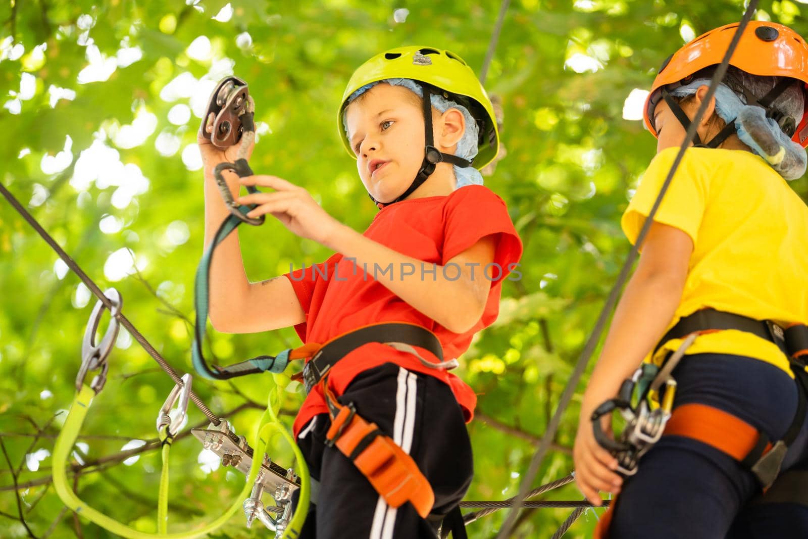 Happy child climbing in the trees. Rope park. Climber child. Early childhood development. Roping park. Balance beam and rope bridges. Rope park - climbing center by Andelov13