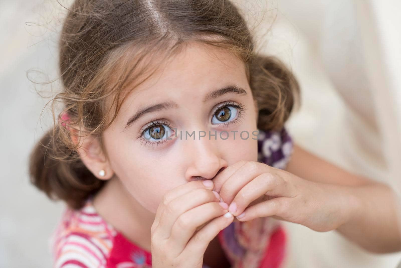 Adorable little girl combed with pigtails outdoors.