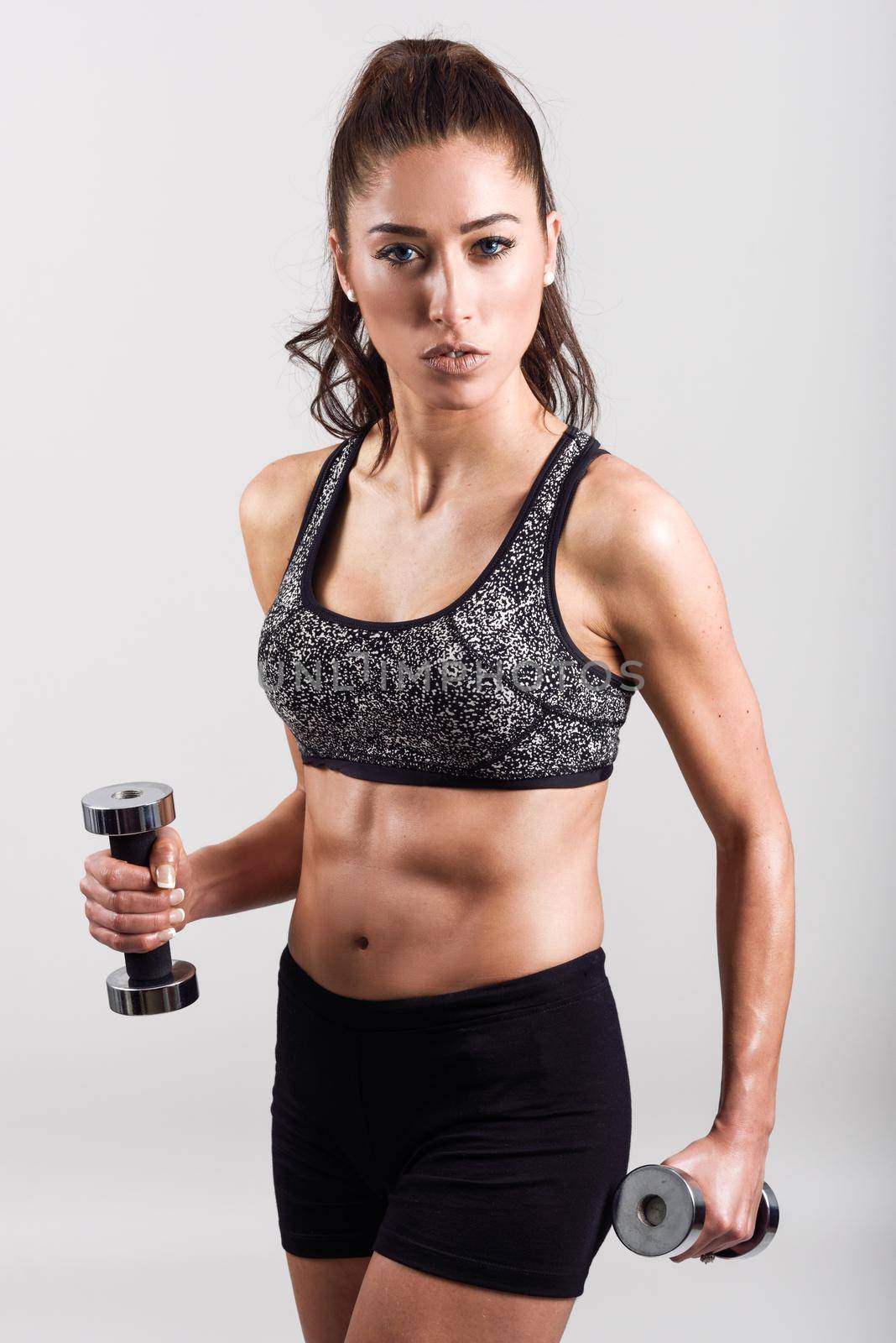Young sports sexy fitness woman body with dumbbells posing on white background.