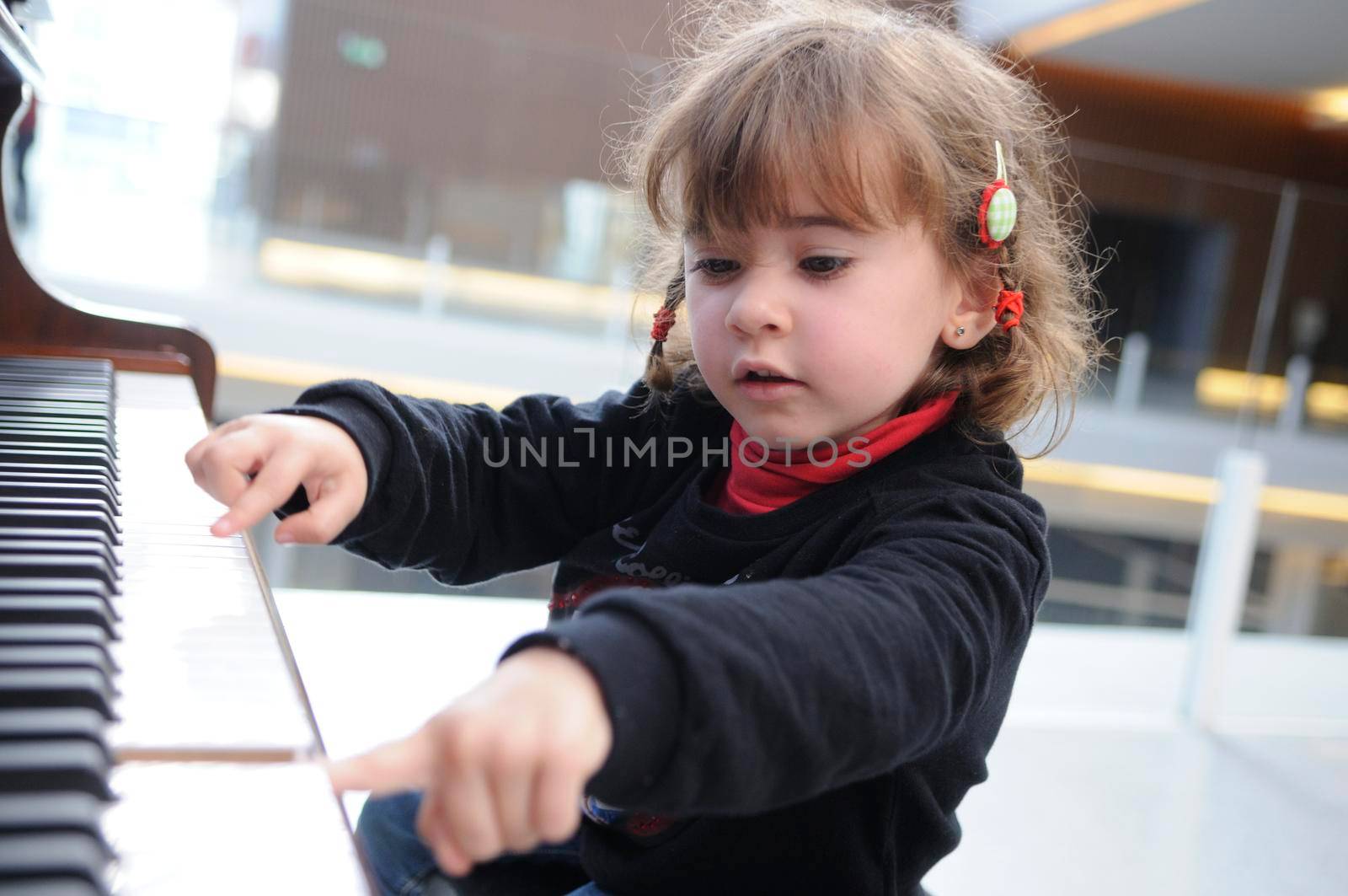 Adorable little girl having fun playing the piano