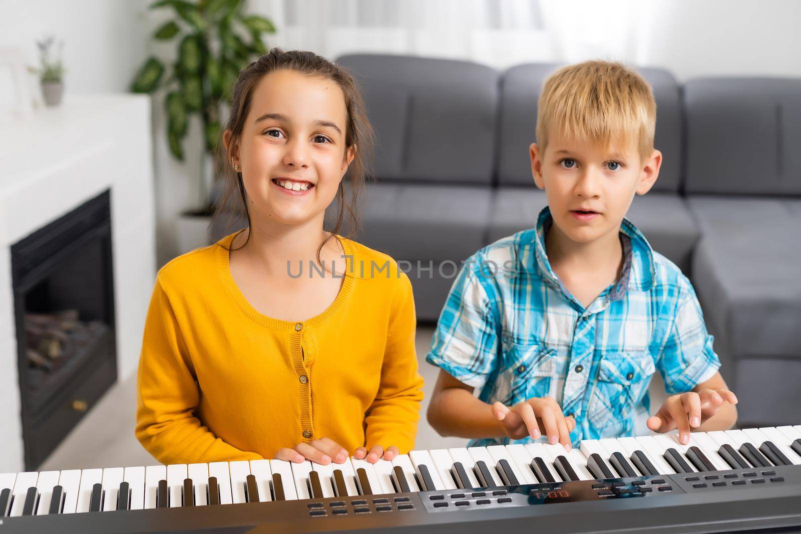 Brother and sister play the synthesizer. Children play at piano. family games.