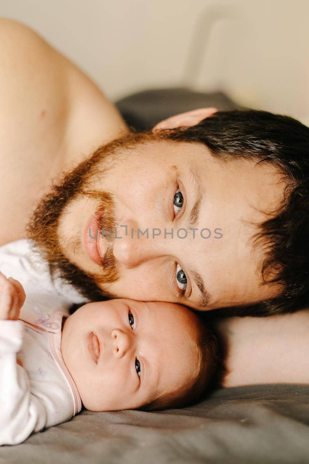 Close up portrait of caucasian happy man holding newborn baby. Concept of tender family photo session with little kids, father with kid and happiness, parenthood. Selective focus
