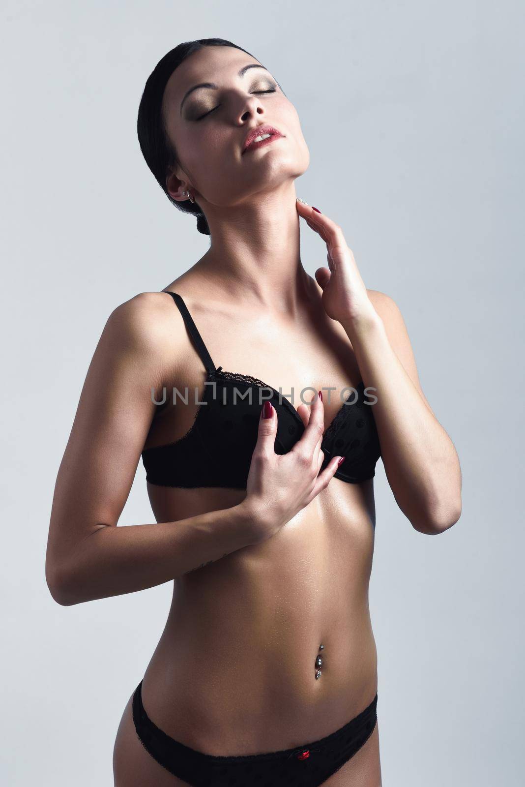 Beautiful brunette woman, model of fashion, wearing black underwear. Young girl in lingerie. Studio shot.