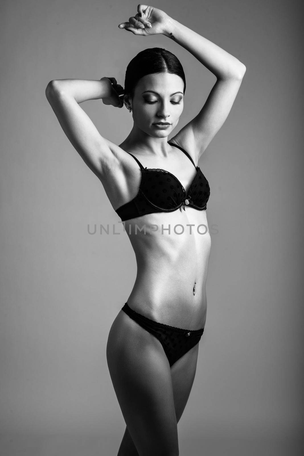 Beautiful brunette woman, model of fashion, wearing black underwear. Young girl in lingerie. Studio shot.