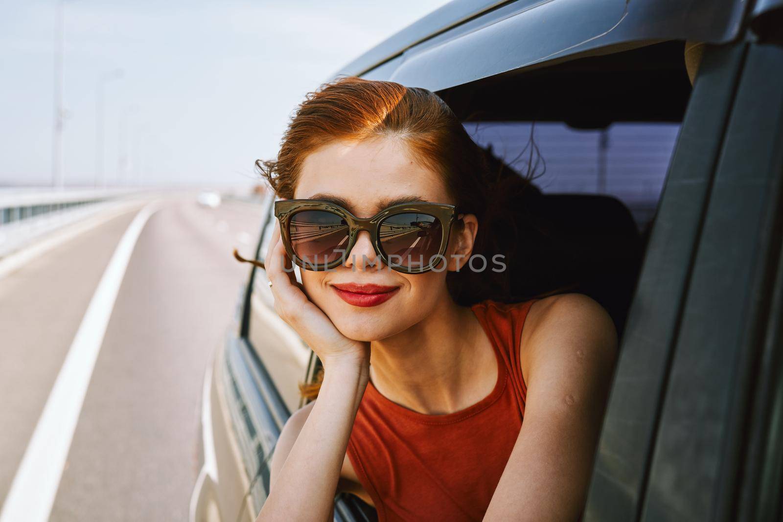 pretty woman in sunglasses rides in a travel car. High quality photo
