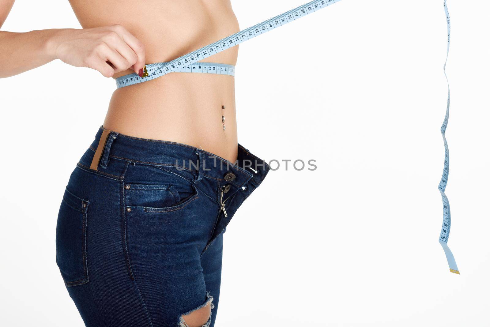 Young woman measuring waist with a tape by javiindy