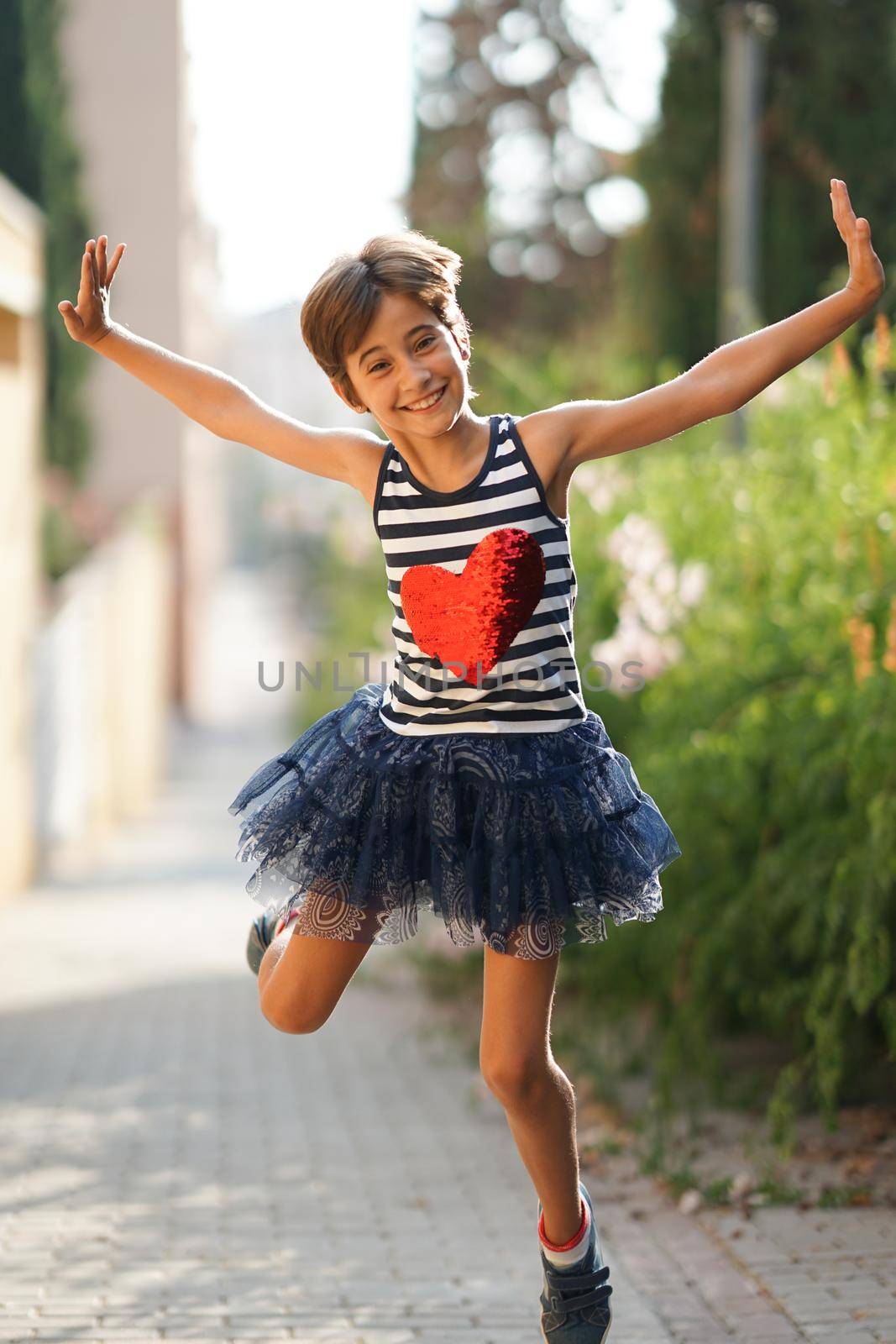 Little girl, eight years old, jumping in an urban park.