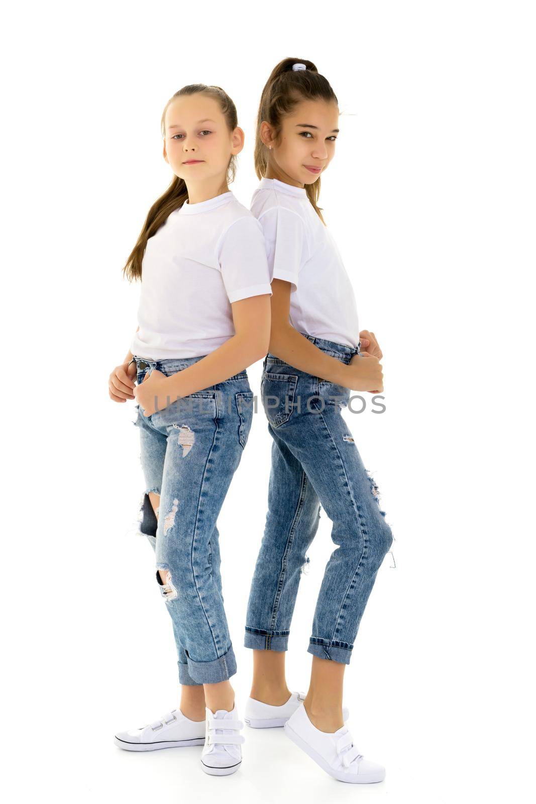 Two cute little girls in full growth, in the studio on a white background. The concept of a happy childhood, Beauty and fashion. Isolated.