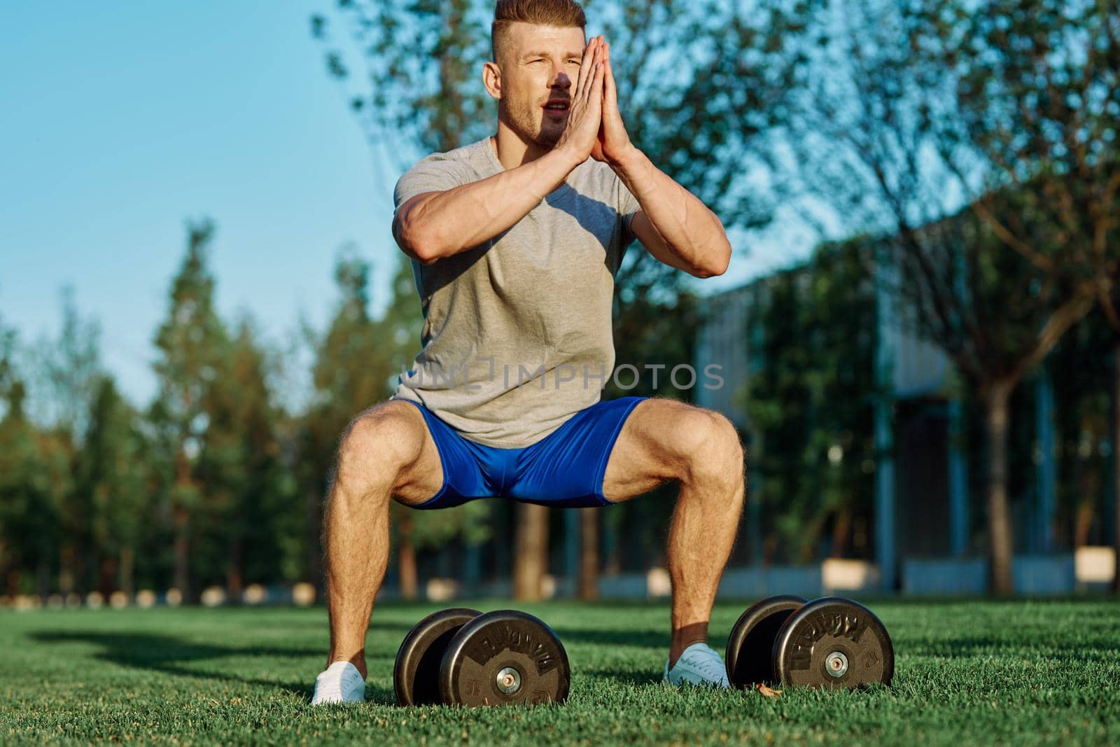 male athlete park with dumbbells doing CrossFit exercise by Vichizh