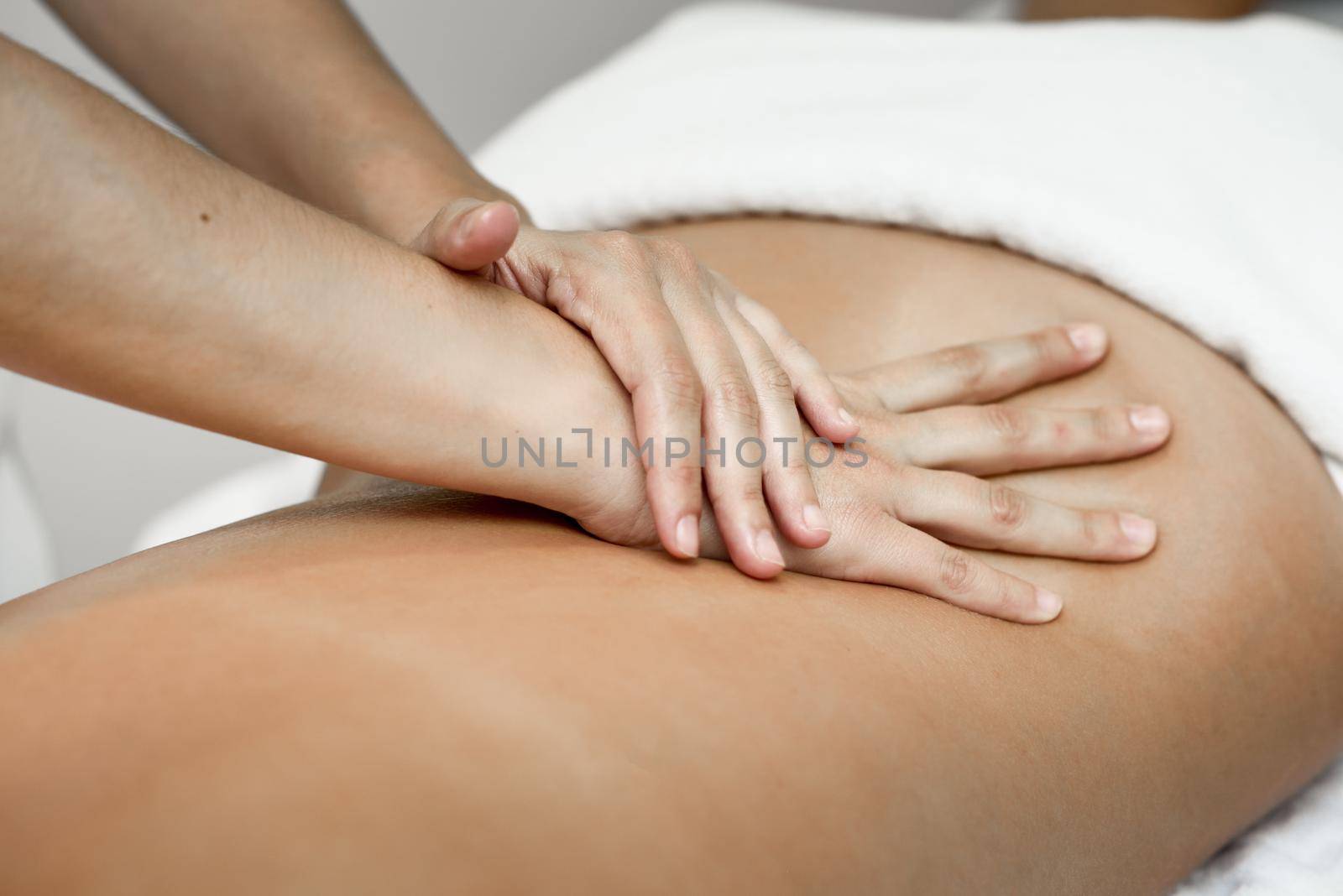 Young woman receiving a back massage in a spa center. by javiindy