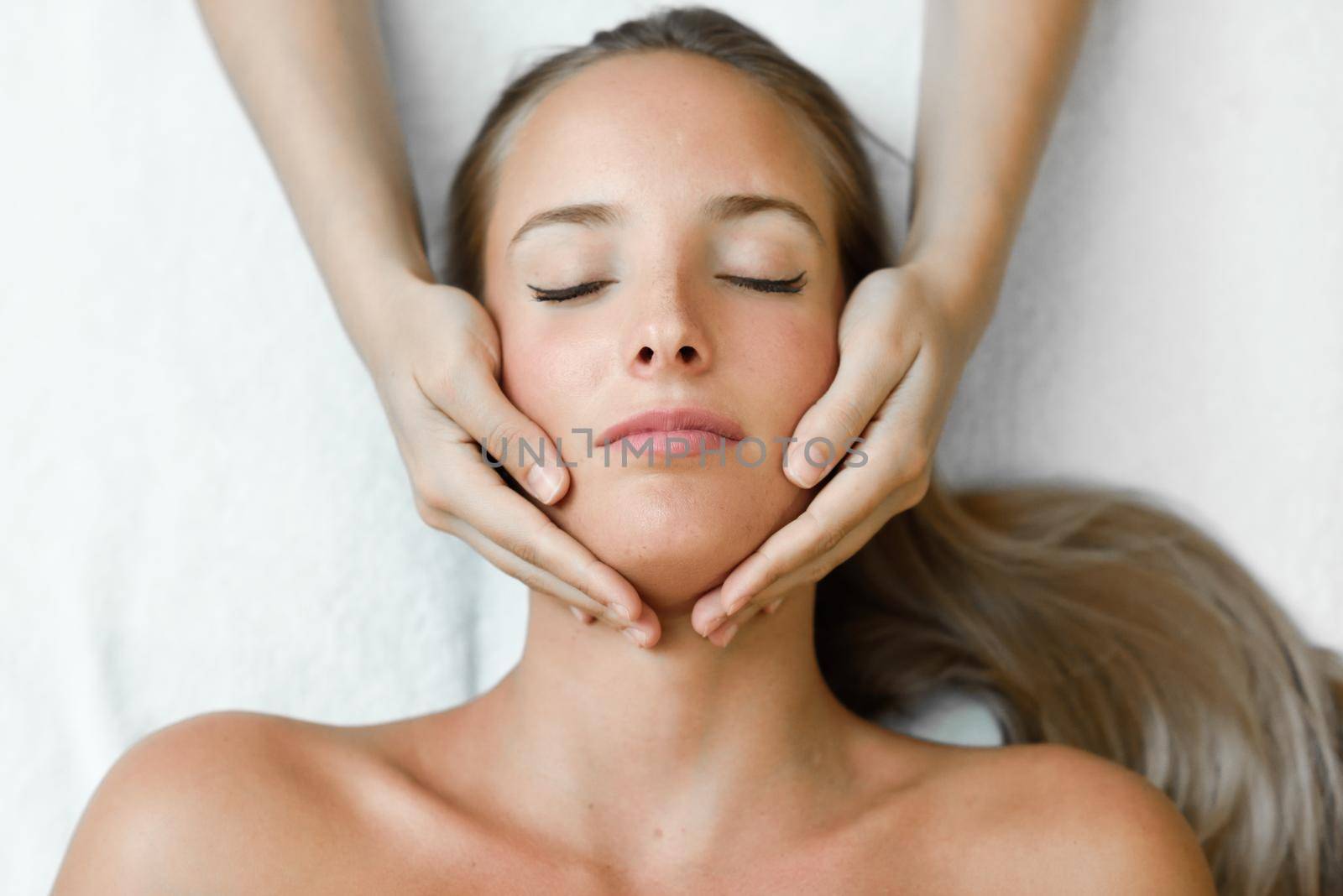 Young woman receiving a head massage in a spa center. by javiindy