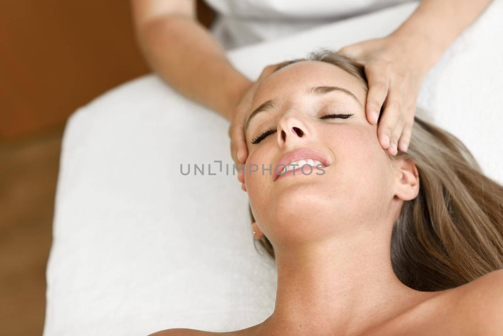 Young woman receiving a head massage in a spa center. by javiindy